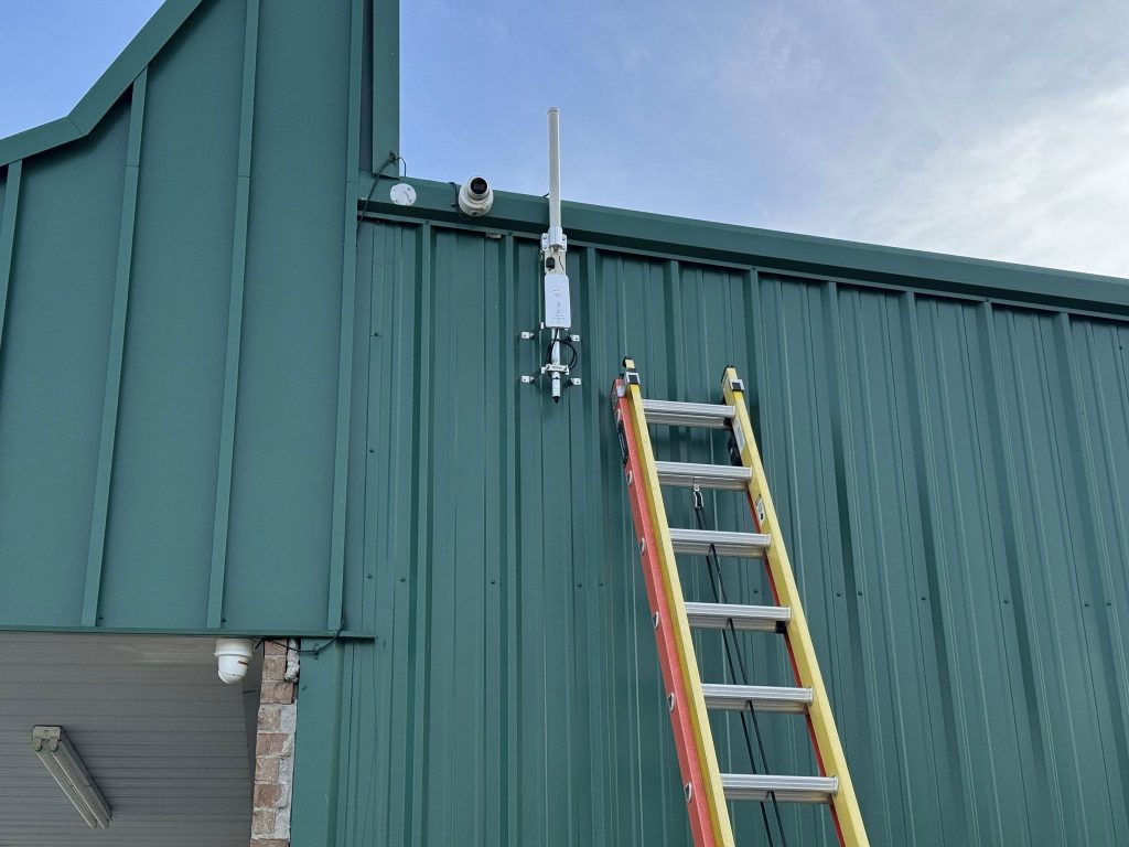 Commercial security camera and long-distance wireless antenna installation on metal building in South Louisiana.